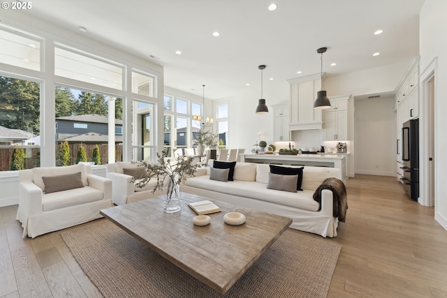 living room with a notable chandelier and light wood-type flooring