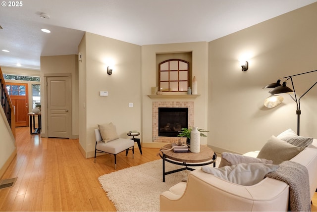 9400 SW 153rd Ave, Beaverton, OR 97007 - living area with a tile fireplace, light wood-style flooring, recessed lighting, and stairway