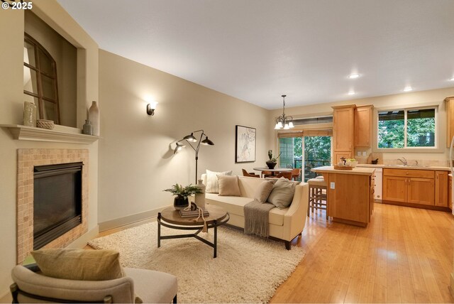 9400 SW 153rd Ave, Beaverton, OR 97007 - living area with a chandelier, light wood-style flooring, a fireplace, and recessed lighting