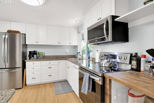 3580 Wilshire Ln, Eugene, OR 97405 - kitchen with stainless steel appliances, white cabinetry, light wood finished floors, recessed lighting, and wooden counters