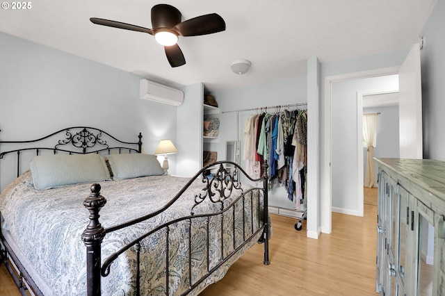 3580 Wilshire Ln, Eugene, OR 97405 - bedroom featuring a wall mounted air conditioner, light wood-type flooring, a ceiling fan, and a closet