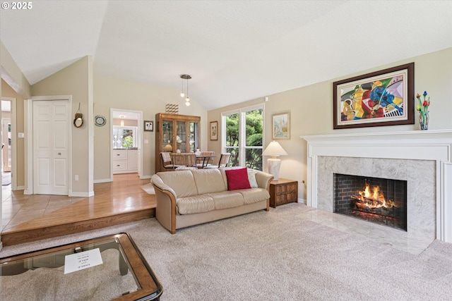 515 SW Colony Dr, Portland, OR 97219 - carpeted living area with lofted ceiling, a fireplace, and baseboards