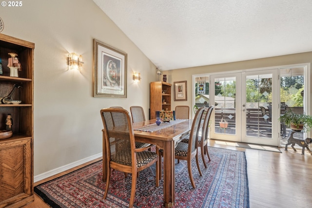515 SW Colony Dr, Portland, OR 97219 - dining area with lofted ceiling, wood finished floors, french doors, a textured ceiling, and baseboards