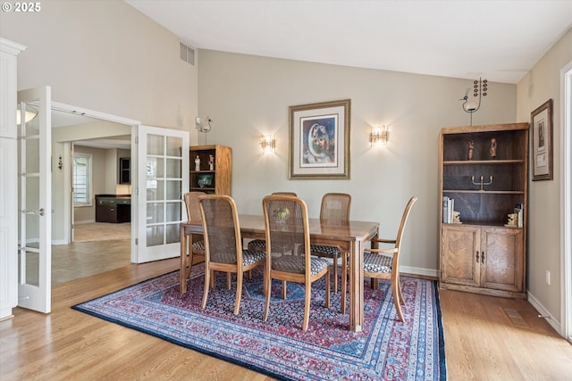515 SW Colony Dr, Portland, OR 97219 - dining room with french doors, wood finished floors, baseboards, and high vaulted ceiling