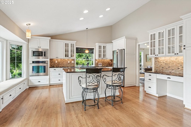 515 SW Colony Dr, Portland, OR 97219 - kitchen featuring stainless steel appliances, dark countertops, backsplash, white cabinets, and lofted ceiling