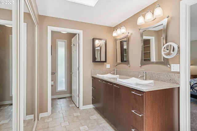 515 SW Colony Dr, Portland, OR 97219 - full bathroom featuring double vanity, baseboards, tile patterned flooring, and a skylight