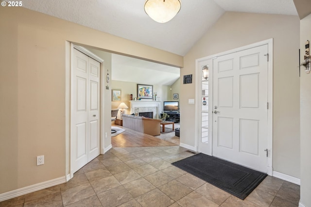 515 SW Colony Dr, Portland, OR 97219 - foyer entrance with lofted ceiling, a fireplace, and baseboards