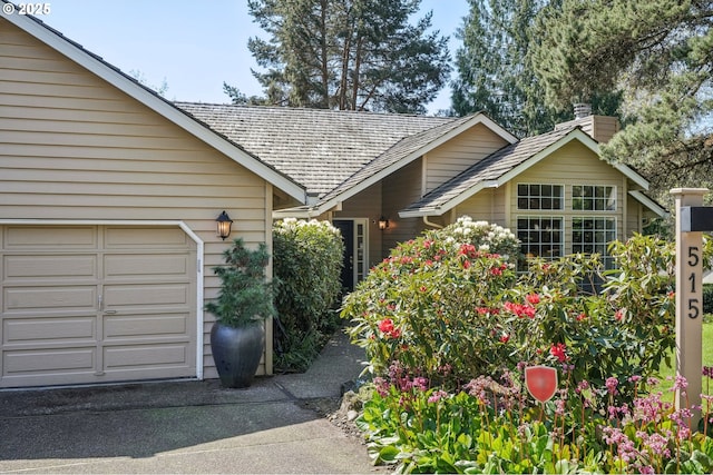 515 SW Colony Dr, Portland, OR 97219 - view of home's exterior with concrete driveway, an attached garage, and a chimney