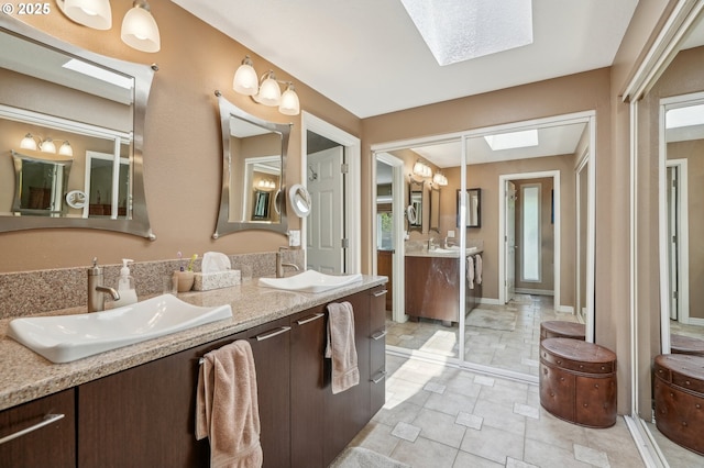 515 SW Colony Dr, Portland, OR 97219 - bathroom with a skylight, double vanity, and tile patterned flooring