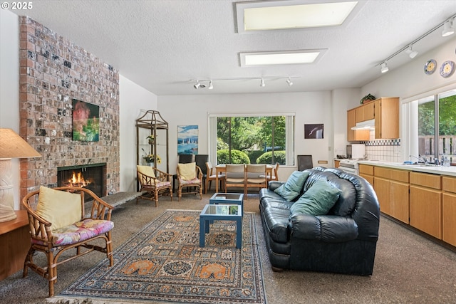 515 SW Colony Dr, Portland, OR 97219 - living room with track lighting, a brick fireplace, and a textured ceiling