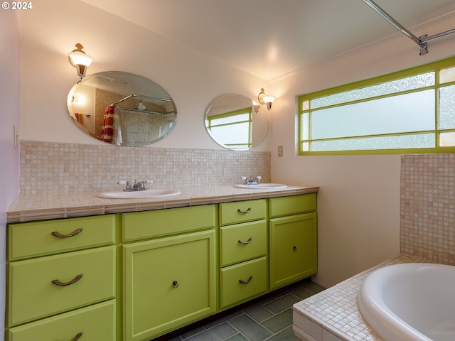 bathroom featuring a relaxing tiled tub, vanity, and backsplash