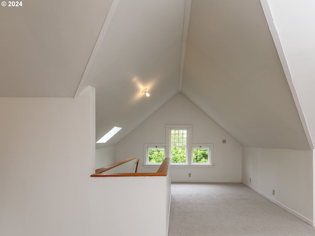 additional living space featuring lofted ceiling and light carpet