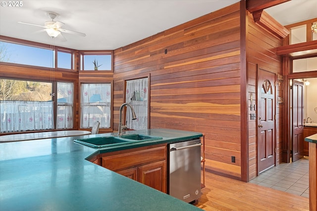 155 N 6th Ave, Elgin, OR 97827 - kitchen with dishwasher, a sink, ceiling fan, wooden walls, and light wood-type flooring