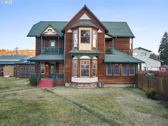 155 N 6th Ave, Elgin, OR 97827 - rear view of property featuring a balcony, covered porch, a storage shed, and an outdoor structure