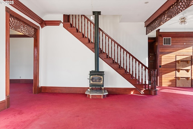 155 N 6th Ave, Elgin, OR 97827 - staircase with carpet, a wood stove, and baseboards