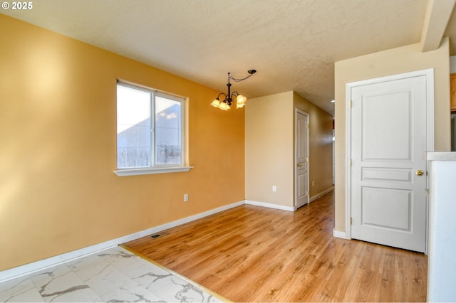 unfurnished room with light hardwood / wood-style floors and a chandelier