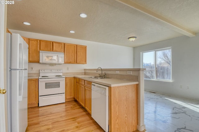 kitchen featuring sink, a textured ceiling, light hardwood / wood-style flooring, kitchen peninsula, and white appliances