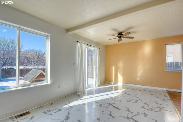 unfurnished room featuring ceiling fan, plenty of natural light, and a textured ceiling