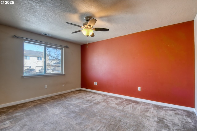 carpeted empty room featuring ceiling fan and a textured ceiling