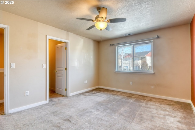 unfurnished room featuring ceiling fan, light colored carpet, and a textured ceiling