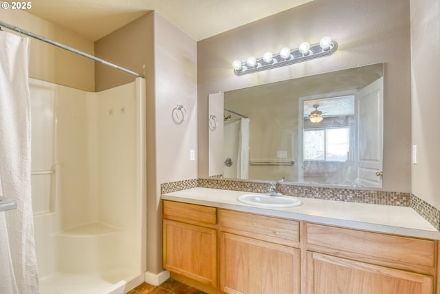 bathroom with ceiling fan, vanity, and curtained shower