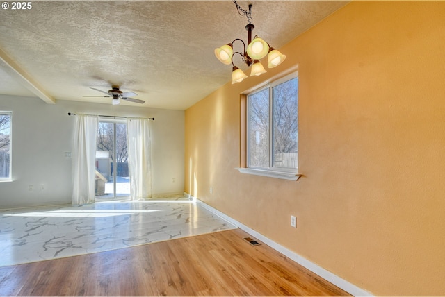 interior space with hardwood / wood-style flooring, ceiling fan with notable chandelier, and a textured ceiling