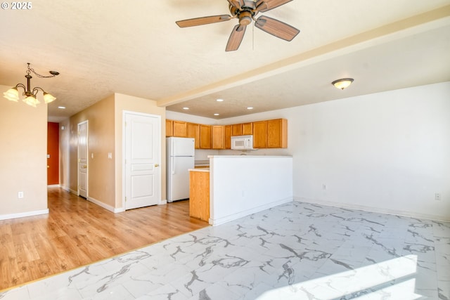 kitchen featuring hanging light fixtures, ceiling fan with notable chandelier, and white appliances