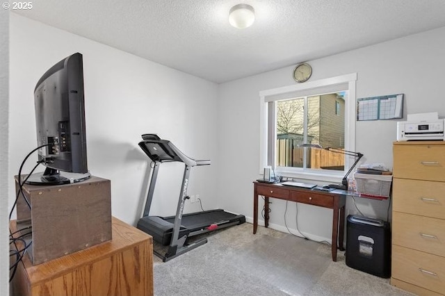 workout area featuring carpet floors and a textured ceiling