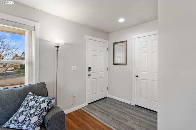 foyer featuring wood finished floors and baseboards