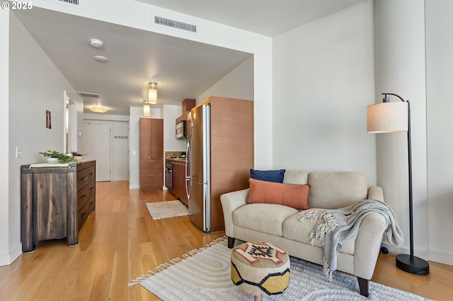 living room featuring visible vents and light wood-style flooring