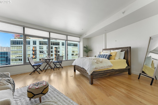 bedroom featuring baseboards and light wood finished floors