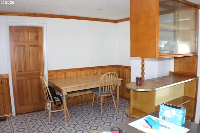 dining space featuring a textured ceiling and ornamental molding