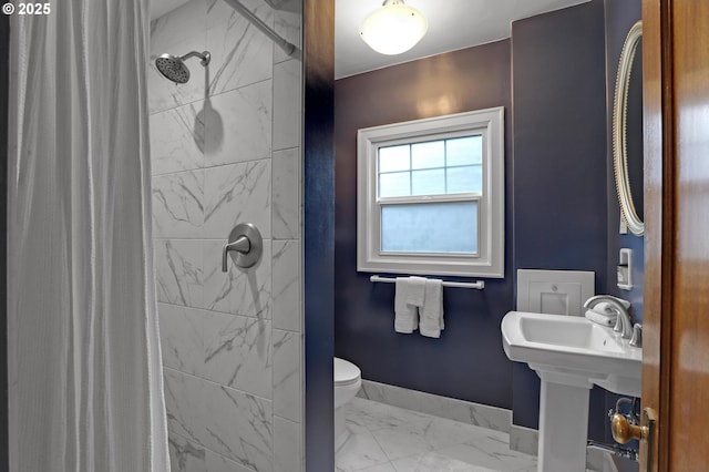 bathroom with baseboards, toilet, marble finish floor, and a stall shower