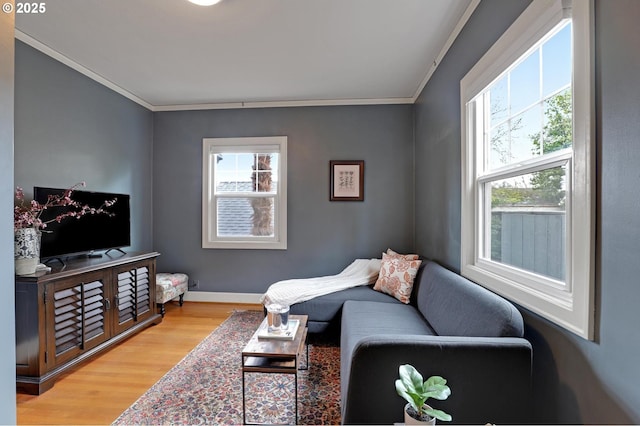 living room with baseboards, ornamental molding, and light wood finished floors