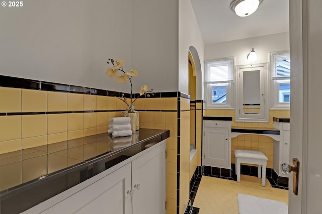 laundry room featuring light tile patterned flooring, a wainscoted wall, and tile walls