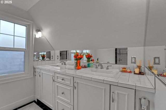 full bath featuring a sink, lofted ceiling, and double vanity