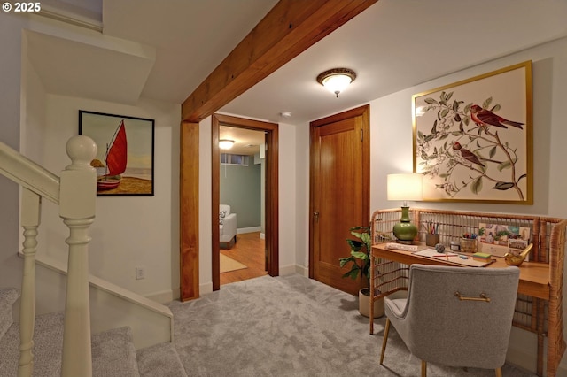 carpeted office space featuring beamed ceiling and baseboards