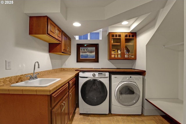 laundry room with a sink, recessed lighting, and washing machine and clothes dryer