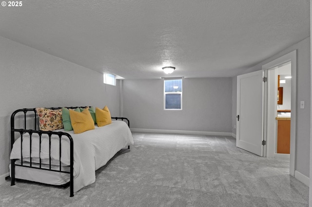 bedroom with baseboards, a textured ceiling, and carpet