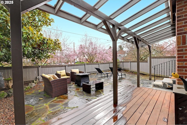 deck with outdoor lounge area, a fenced backyard, and a pergola