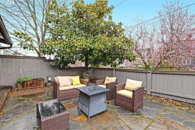 view of patio with an outdoor living space with a fire pit and a fenced backyard