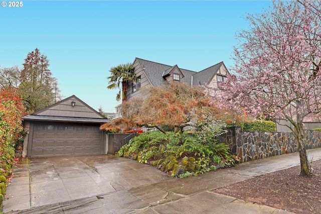 view of front facade with a fenced front yard, driveway, and a garage