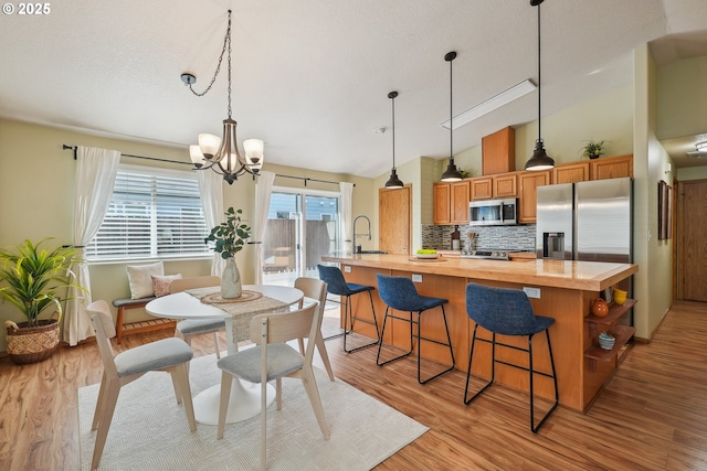 2383 SE 61st Ln, Hillsboro, OR 97123 - dining area featuring vaulted ceiling, a chandelier, and light wood-style flooring