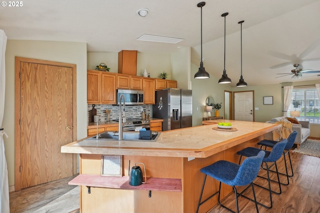 2383 SE 61st Ln, Hillsboro, OR 97123 - kitchen featuring stainless steel appliances, light countertops, tasteful backsplash, and a kitchen bar