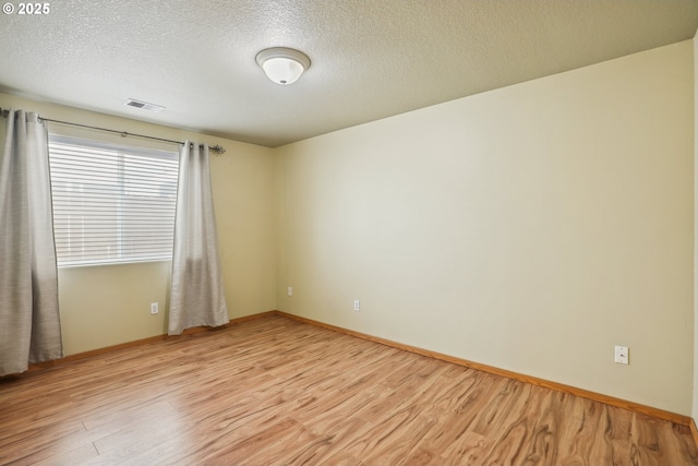 2383 SE 61st Ln, Hillsboro, OR 97123 - spare room with light wood finished floors, a textured ceiling, and baseboards