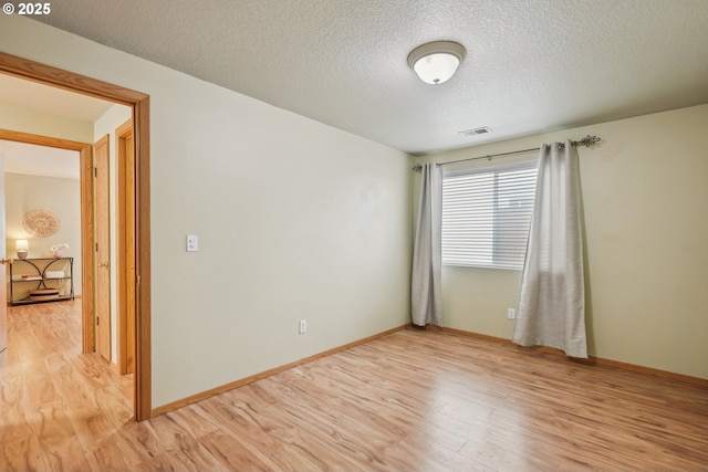 2383 SE 61st Ln, Hillsboro, OR 97123 - empty room with light wood-style floors, a textured ceiling, and baseboards