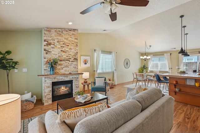 2383 SE 61st Ln, Hillsboro, OR 97123 - living area featuring vaulted ceiling, ceiling fan, a tile fireplace, wood finished floors, and baseboards