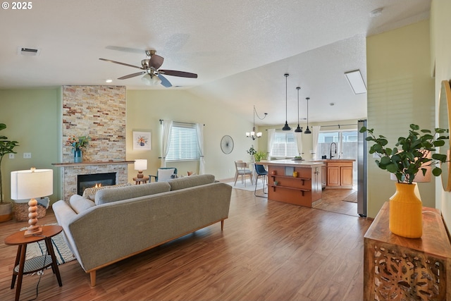 2383 SE 61st Ln, Hillsboro, OR 97123 - living area featuring lofted ceiling, wood finished floors, ceiling fan, healthy amount of natural light, and a large fireplace