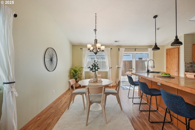 2383 SE 61st Ln, Hillsboro, OR 97123 - dining room featuring wood finished floors, a chandelier, and baseboards