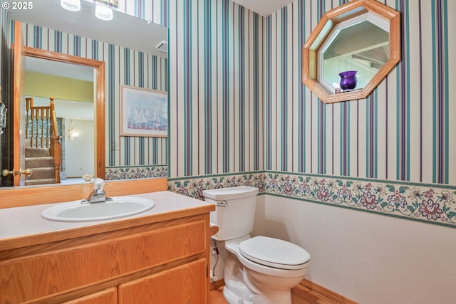 230 S Maple Hill Rd, Kelso, WA 98626 - bathroom with wallpapered walls, toilet, vanity, and wood finished floors